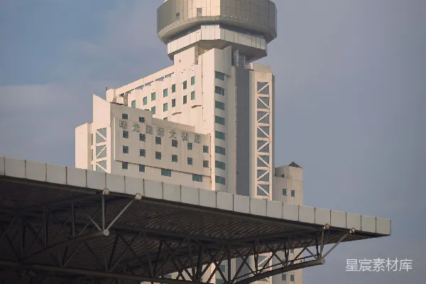 现代高层建筑，顶部部分独具特色，矗立于天空中。