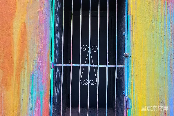 高清摄影 一扇带有栏杆的窗户，背景是色彩斑斓的墙壁。