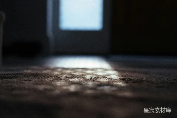 高清摄影 阳光透过明亮的窗户照在黑暗的地毯上。