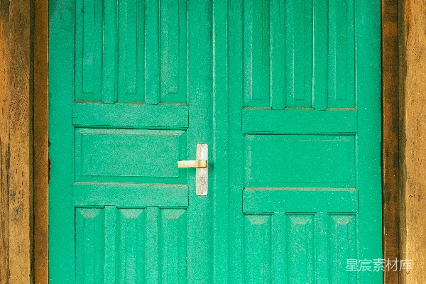 高清摄影 一扇绿色的木门，门上装有一个银色的把手。