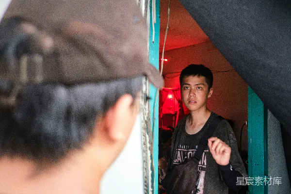 高清摄影 一个穿着红色衣服的年轻人站在门口，看着另一个人。