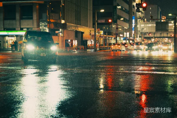 夜晚城市湿滑街道上行驶的汽车。