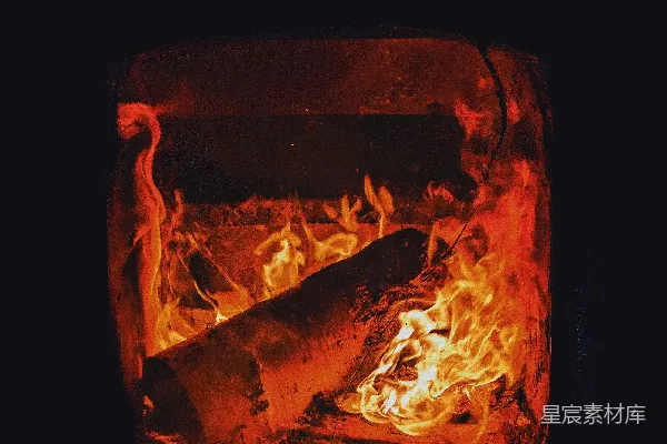 一束火焰在黑暗的壁炉中明亮地燃烧。