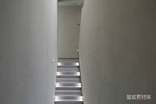 高清摄影 一条长长的窄长廊，墙壁是白色的，地板是黑白条纹的。