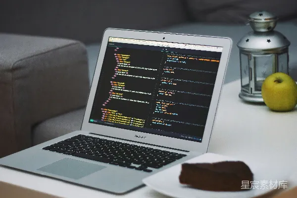 高清摄影 打开桌子旁边的MacBook Air，旁边是一个装有蛋糕的碟子。