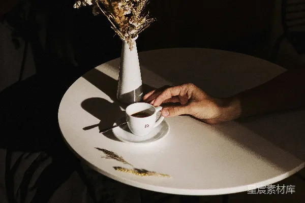 高清摄影 手拿白色陶瓷杯的人站在白色的圆形桌子上。