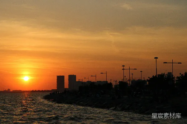 夕阳映照在一片水体上，城市背景中。
