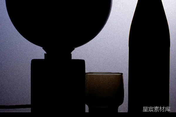 高清摄影 一瓶酒和一个酒杯放在架子上。