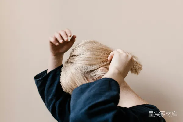 高清摄影 一位金发女子靠在墙上站着。