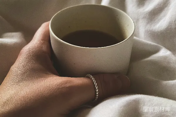 高清摄影 一只手拿着一杯咖啡。