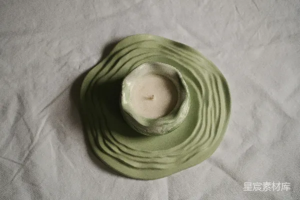 高清摄影 一个绿色的盘子上放着一支白色的蜡烛。