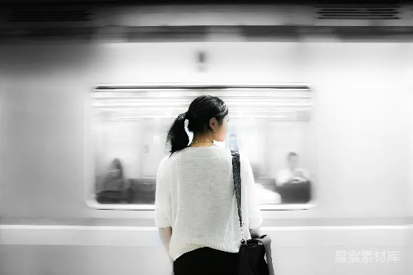 高清摄影 白上衣袖女站在地铁站内的白色火车旁