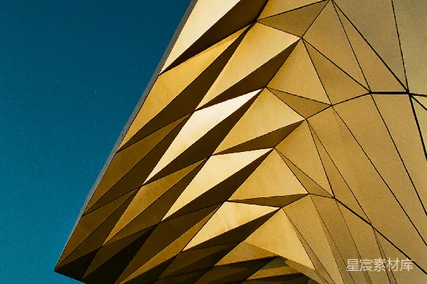 金色的几何建筑矗立在蓝天之下。