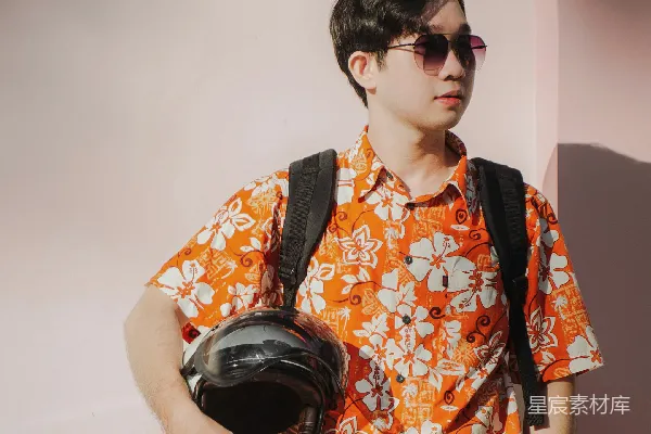 高清摄影 穿橙色和黄色花卉图案纽扣衬衫的男孩戴着黑色耳机