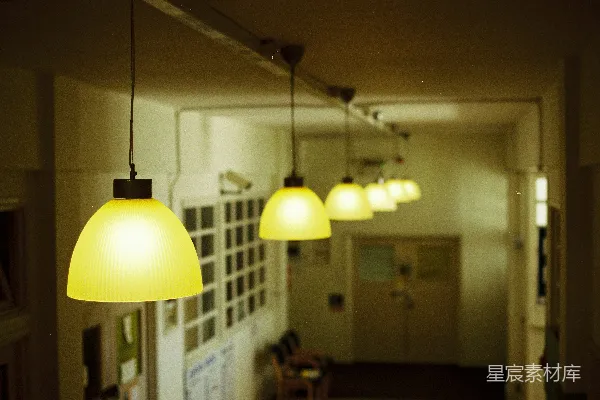高清摄影 一排黄色的吊灯照亮了黑暗的走廊。