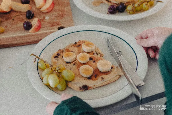 高清摄影 一个人坐在桌子旁，面前有一盘食物。