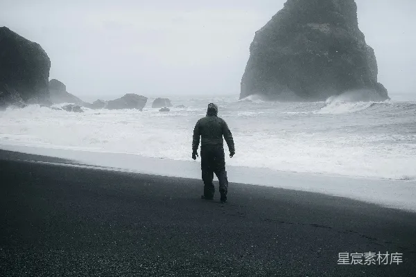 海边一个男人站在沙滩上。