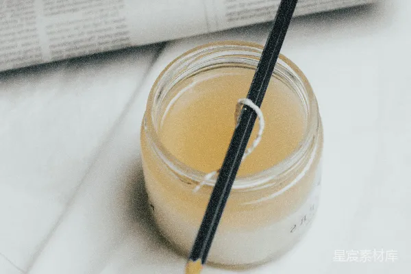 高清摄影 一个装有液体的罐子，上面放着一支笔。