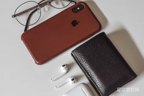 红色和黑色的iPhone壳旁边有一个白色的皮革钱包