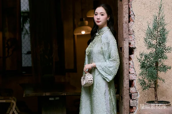 高清摄影 穿着传统浅绿色连衣裙的女子站在门口。