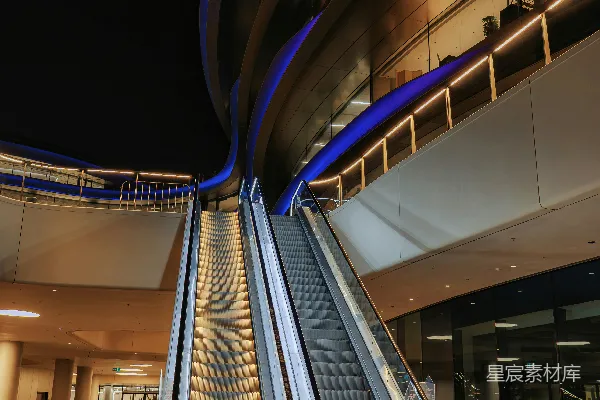现代建筑中电梯在夜晚亮着蓝色灯光上升。