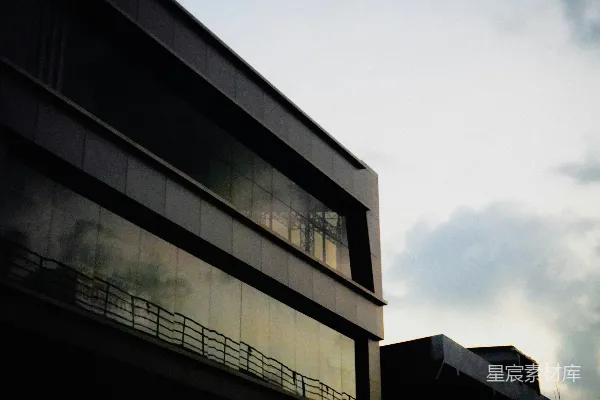 高清摄影 现代建筑，带有反光窗户，背景是多云的天空。
