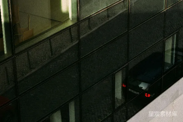 高清摄影 现代的玻璃幕墙建筑反射出一辆车。