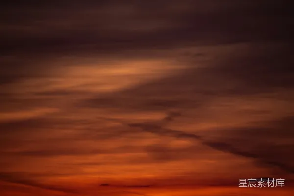 夕阳西下，笼罩着海边的天空。