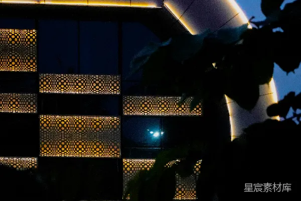 高清摄影 现代建筑在黄昏时分，弯曲的外立面被灯光照亮。