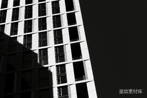 高清摄影 黑白色调的现代建筑，窗户在黑暗的天空下显得格外醒目。