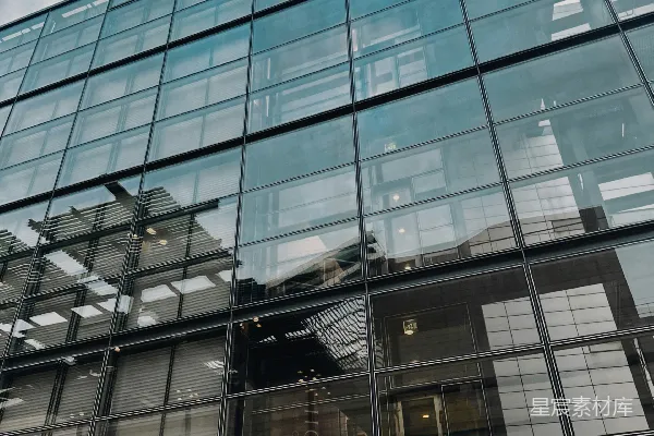高清摄影 现代玻璃建筑立面在多云的天空下反射。
