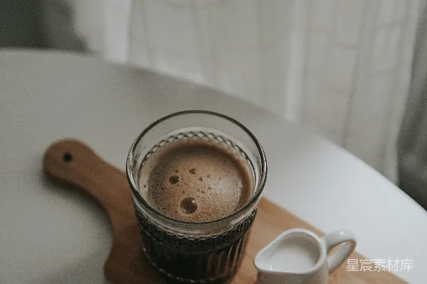 白色陶瓷茶杯放在棕色木桌上