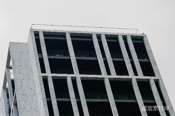 高清摄影 现代混凝土建筑，网格立面，背景是灰色的天空。