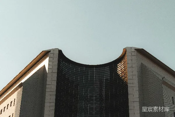 高清摄影 现代化的建筑，其弯曲的玻璃外墙在清澈的天空背景下显得格外引人注目。