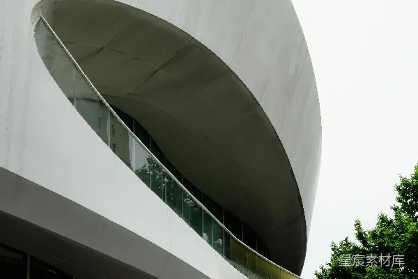 高清摄影 现代化的白色建筑，带有大型椭圆形窗户和阳台。