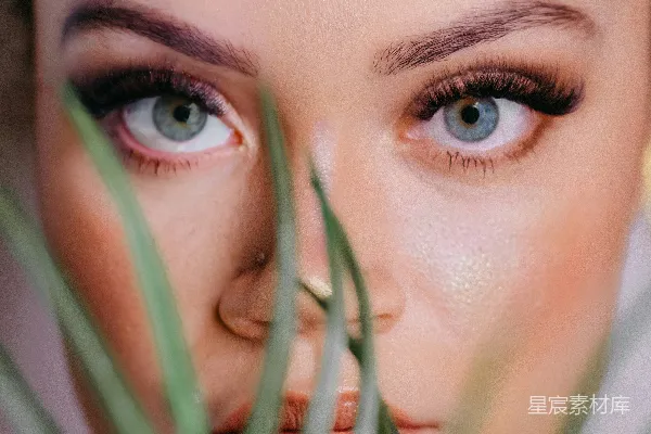 一个蓝眼的女人正在拿着一盆植物。