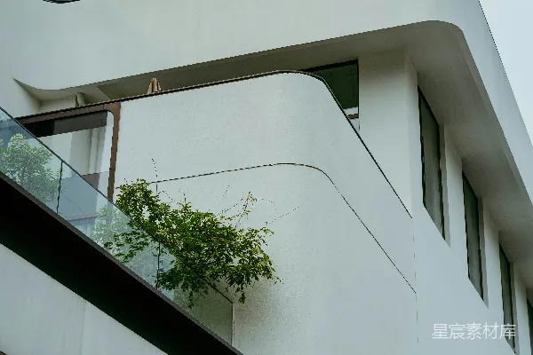 高清摄影 现代化的白色建筑，带有弧形阳台和窗户。