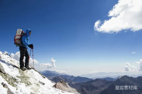 背着背包的男人正在雪山上徒步前行。