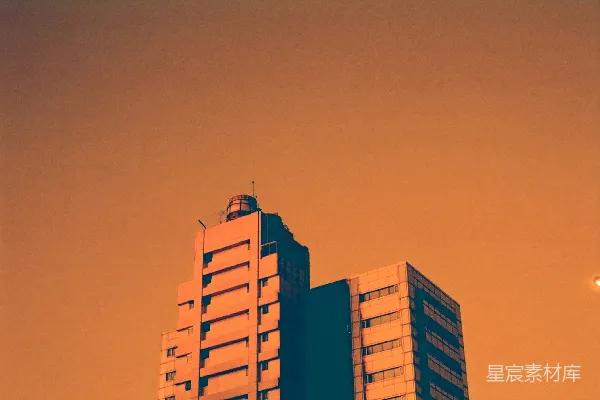 高清摄影 两座高大的建筑物映衬在橙色的天空下