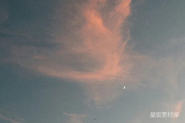 粉色的云彩在暮色的天空中飘动，月亮高悬。