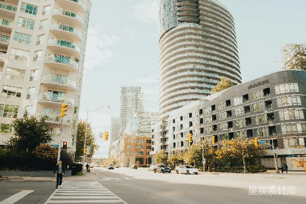 高清摄影 现代化的建筑沿着一条城市街道排列，街道两旁设有人行横道。