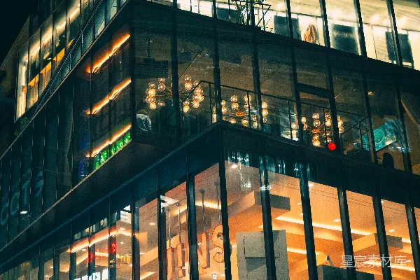 高清摄影 现代玻璃建筑夜晚被暖色调的室内灯光照亮。