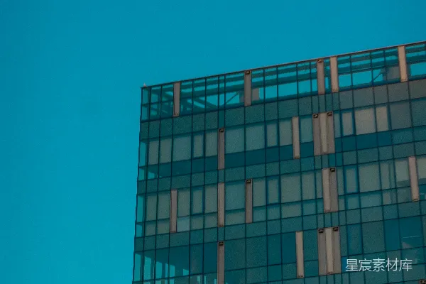 高清摄影 一架飞机正在天空中飞过一座建筑物。