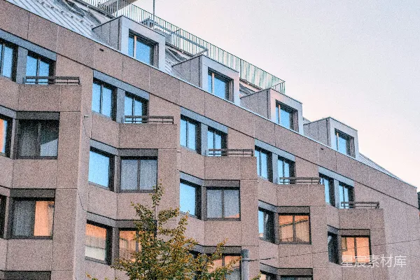 高清摄影 现代化的建筑，带有窗户和树木，背景是天空。