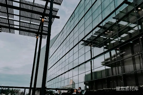 高清摄影 现代化的玻璃建筑，配有户外用餐区。