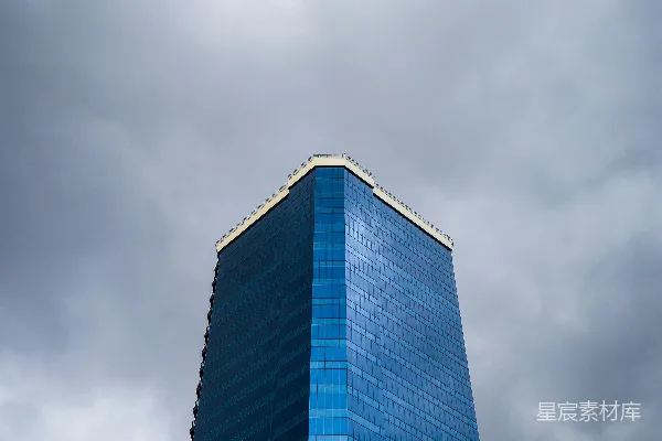 高清摄影 蓝色高大的玻璃摩天大楼矗立在暴风雨的云层中