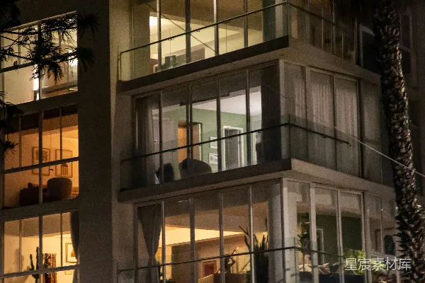 高清摄影 现代建筑，夜晚许多窗户和阳台都亮着灯。