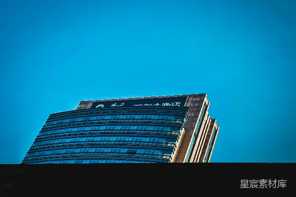 现代玻璃 skyscraper 建筑矗立在蓝天白云之间。