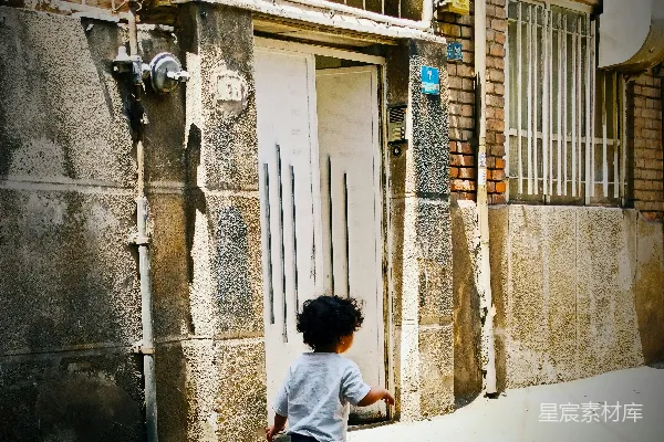 一个小孩正在一栋建筑的前面奔跑。