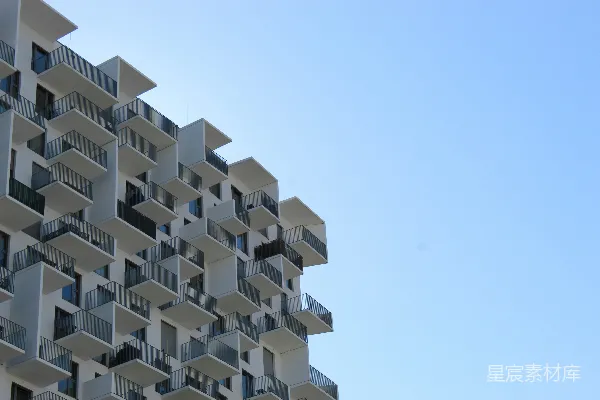 高清摄影 现代化的白色建筑，有许多阳台，背景是蓝天。